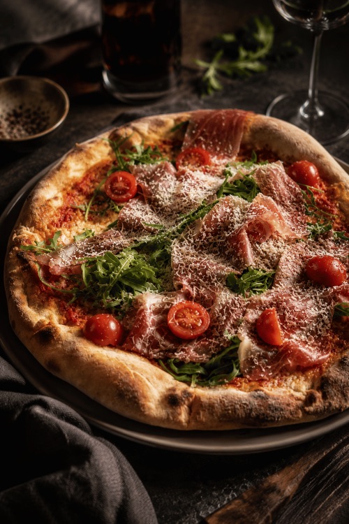 Pizza mit Parmaschinken, Rucola und Parmesan